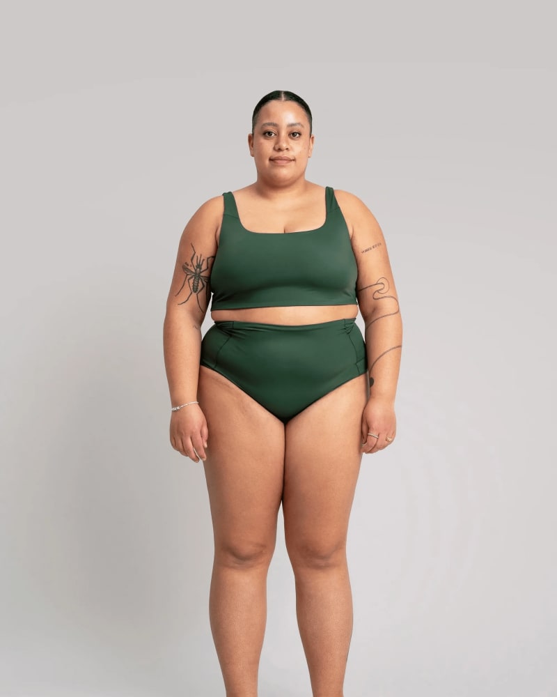 Front of a model wearing a size 3X surf's up swim bikini bottom in sycamore green by alder apparel. | dia_product_style_image_id:296209